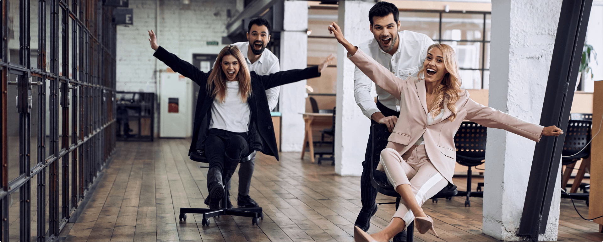 Equipo de trabajo divirtiendose en la oficina en su rato libre, se muestran personas haciendo competensias con las sillas de sus escritorios