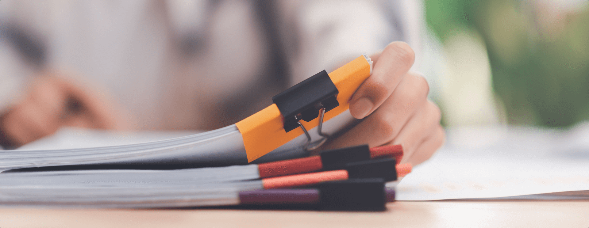 se muestra a un directivo revisando documentos sobre su escritorio